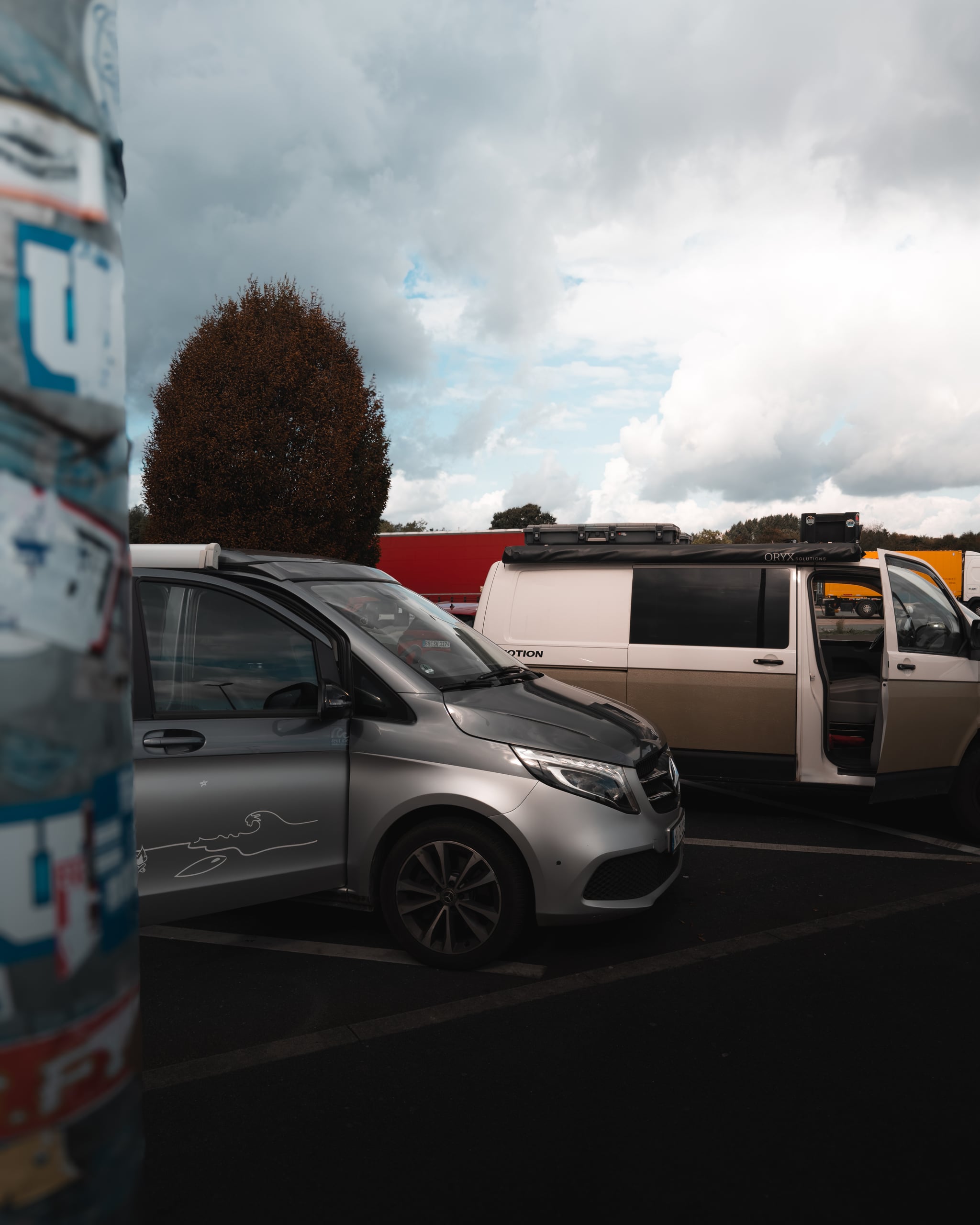 Zwei Camper auf einem Rastplatz unter Wolkenhimmel
